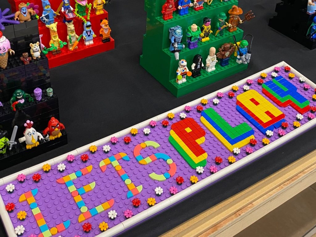 LEGO built mosaic sign saying, Let's Play 